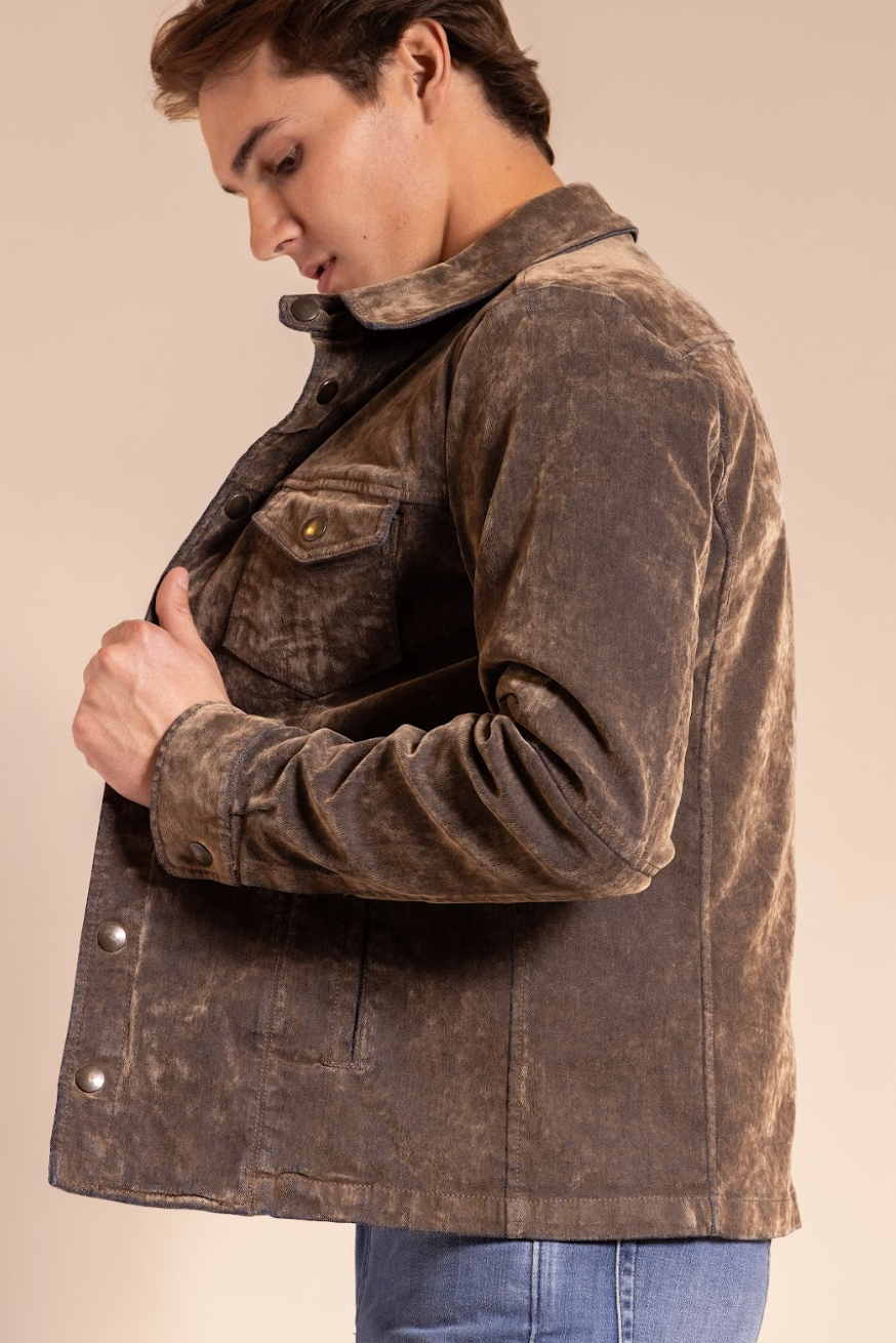 Man wearing a brown distressed jacket against a beige background