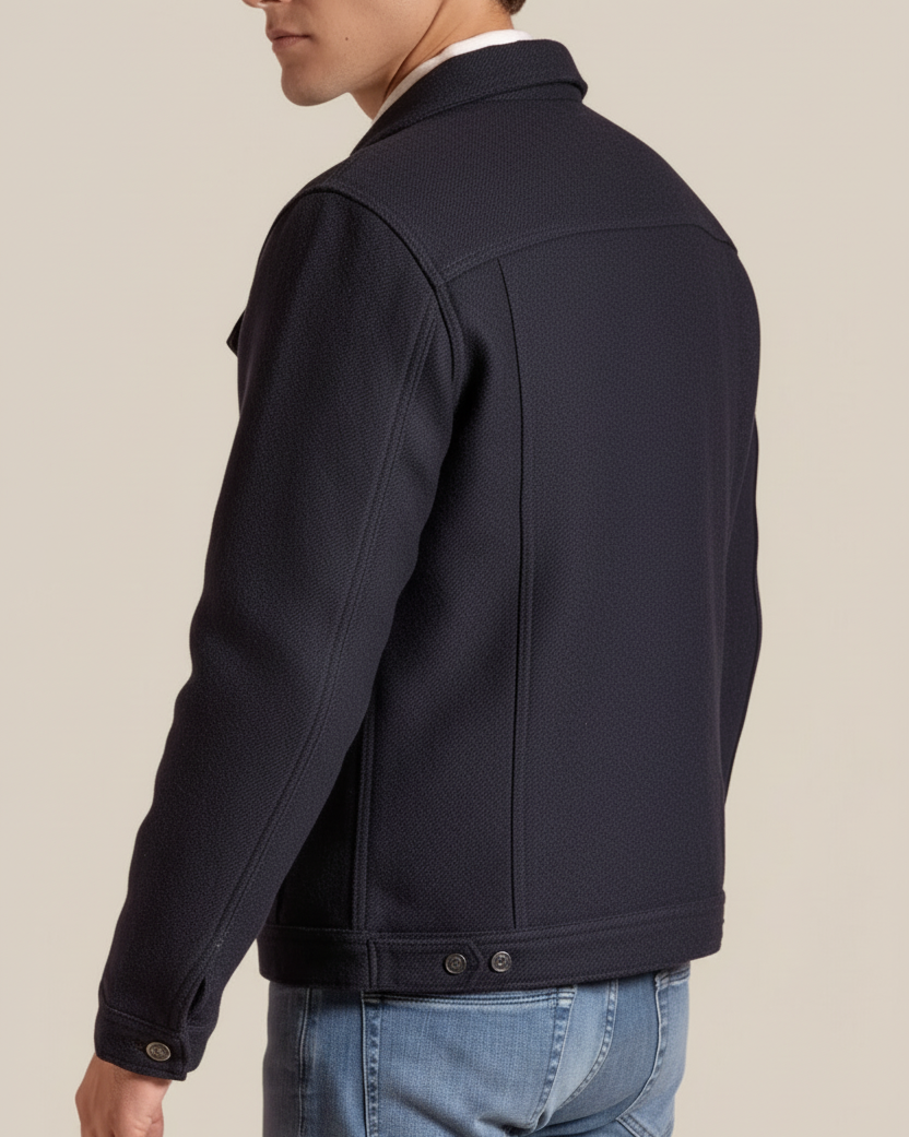 Man wearing a dark jacket with a beige background