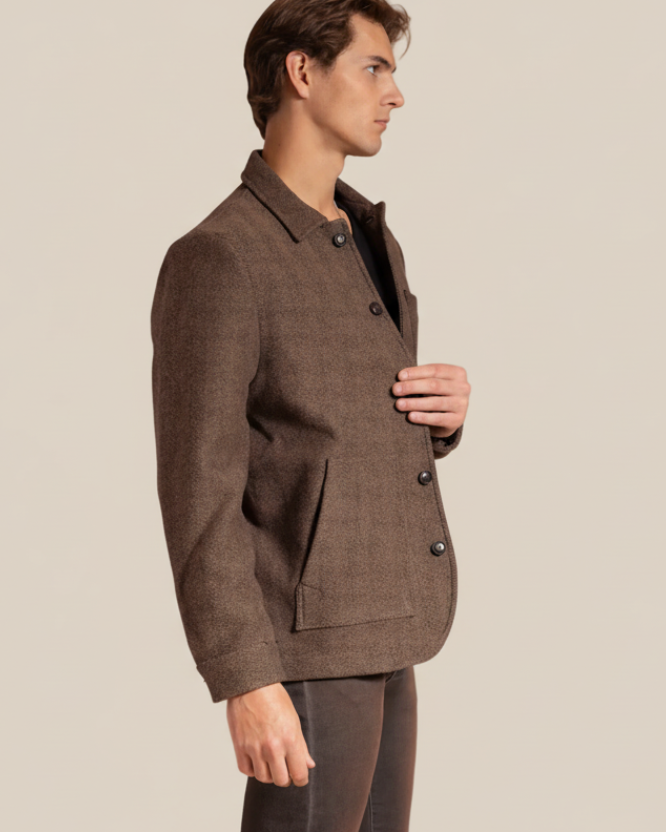 Man wearing a brown suit jacket on a beige background