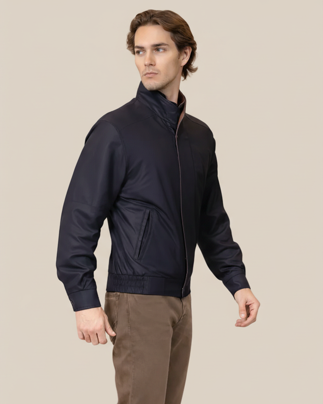 Man wearing a dark blue jacket on a beige background