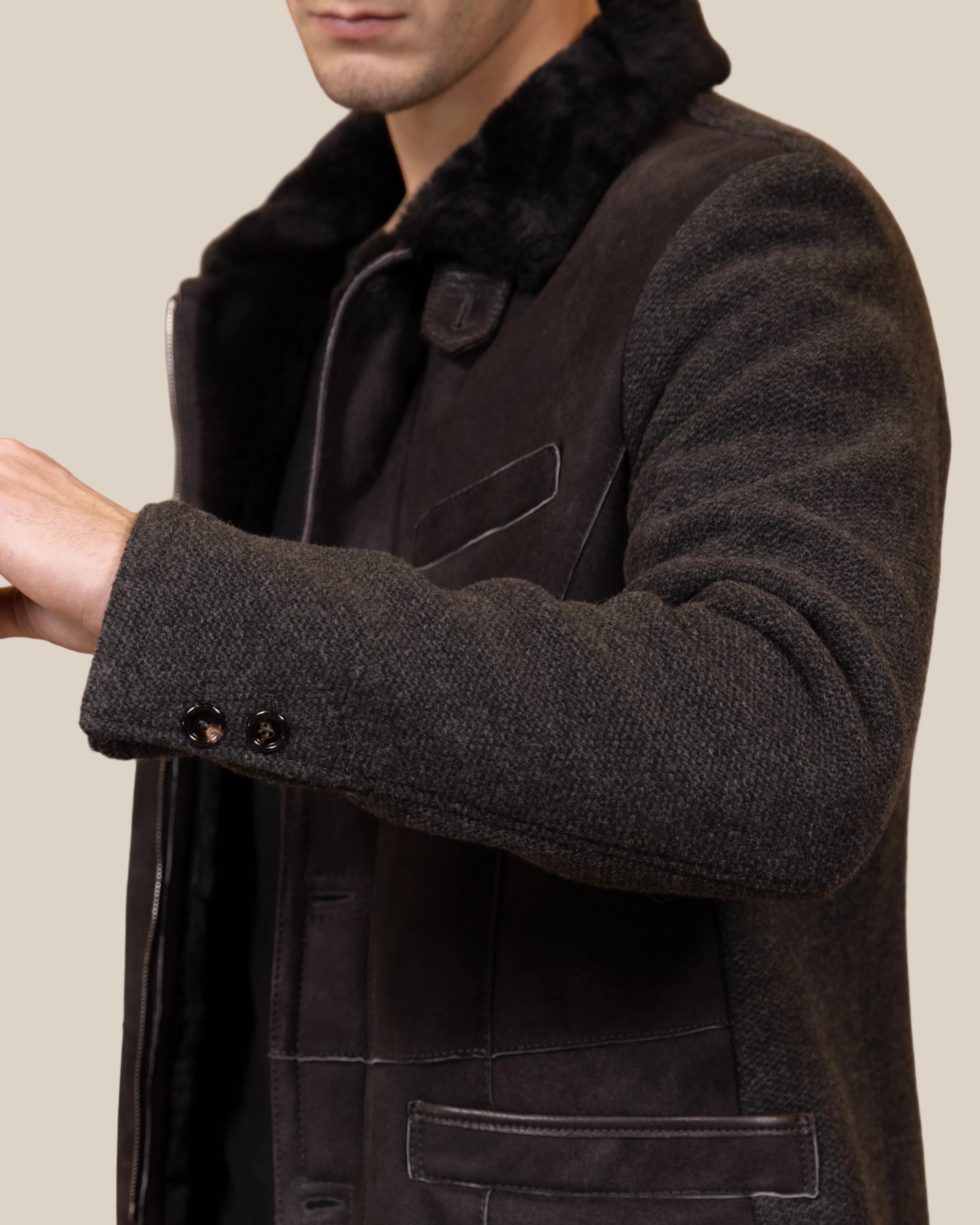 Close-up of a dark brown coat with fur collar on a brown background