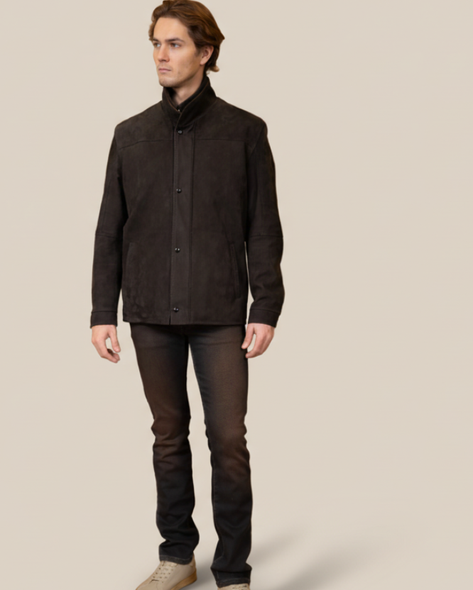 Man wearing a dark jacket and pants on a beige background