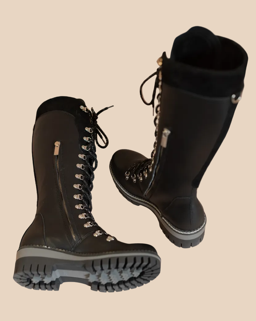 Black winter boots with fur lining on a beige background